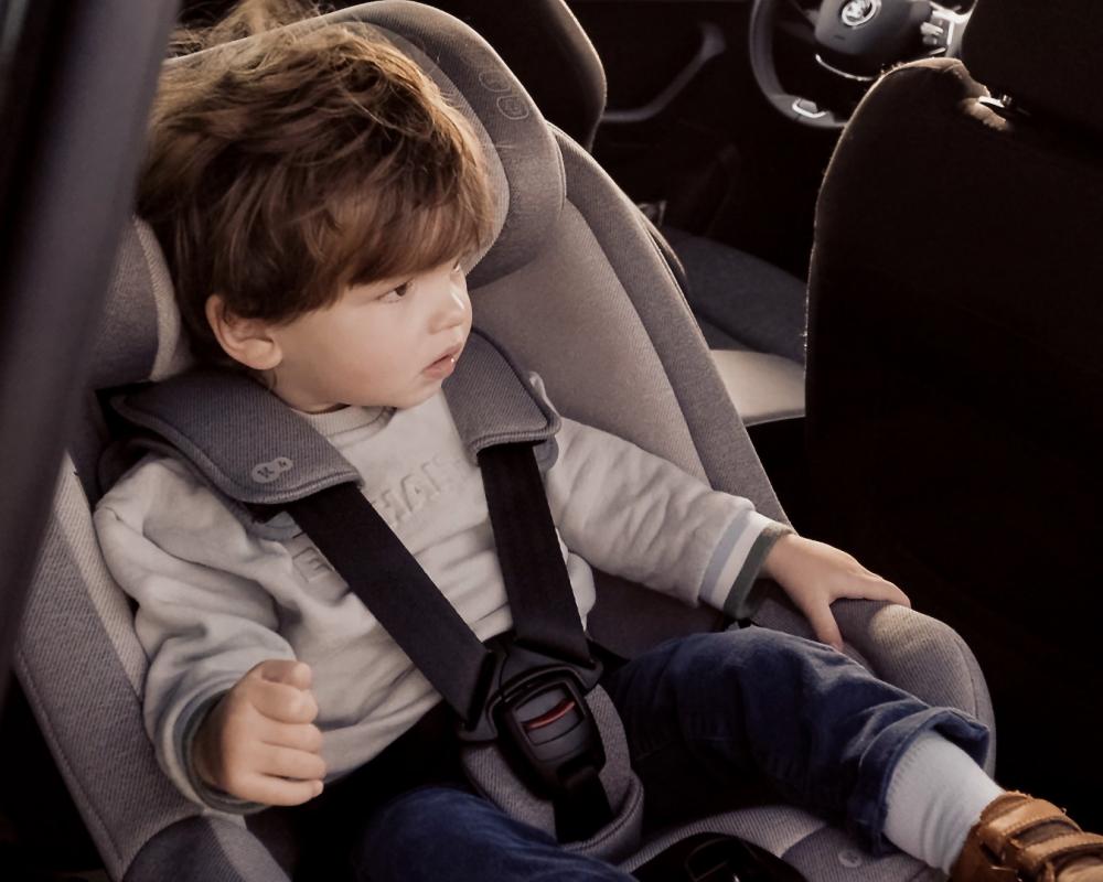 A boy sitting in the I-GUARD car seat installed in the car