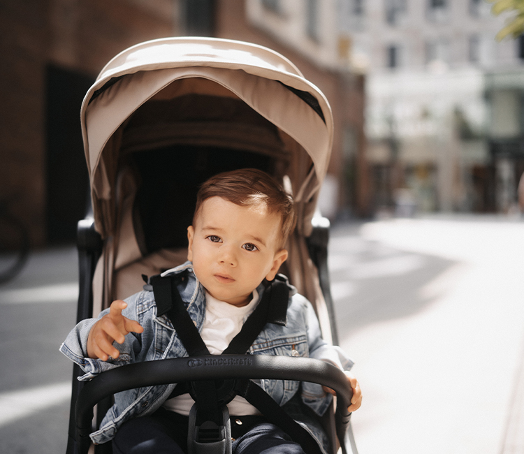 A young boy sitting in the compact Kinderkraft NUBI 2 pushchair looking directly at the camera lens
